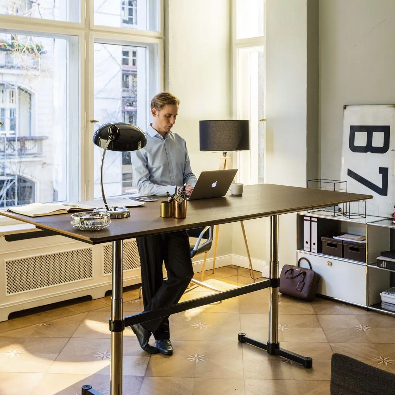 pessoa trabalhando em pé na mesa com altura regulável