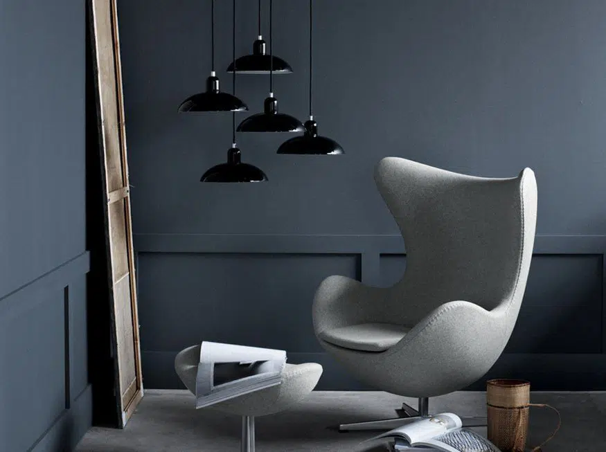 luminárias decorativas KAISER Idell Pendant na cor preta ao lado de uma Egg Chair branca