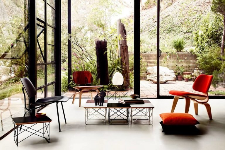 Ambiente Eames: cadeiras ao redor de uma mesa em uma sala