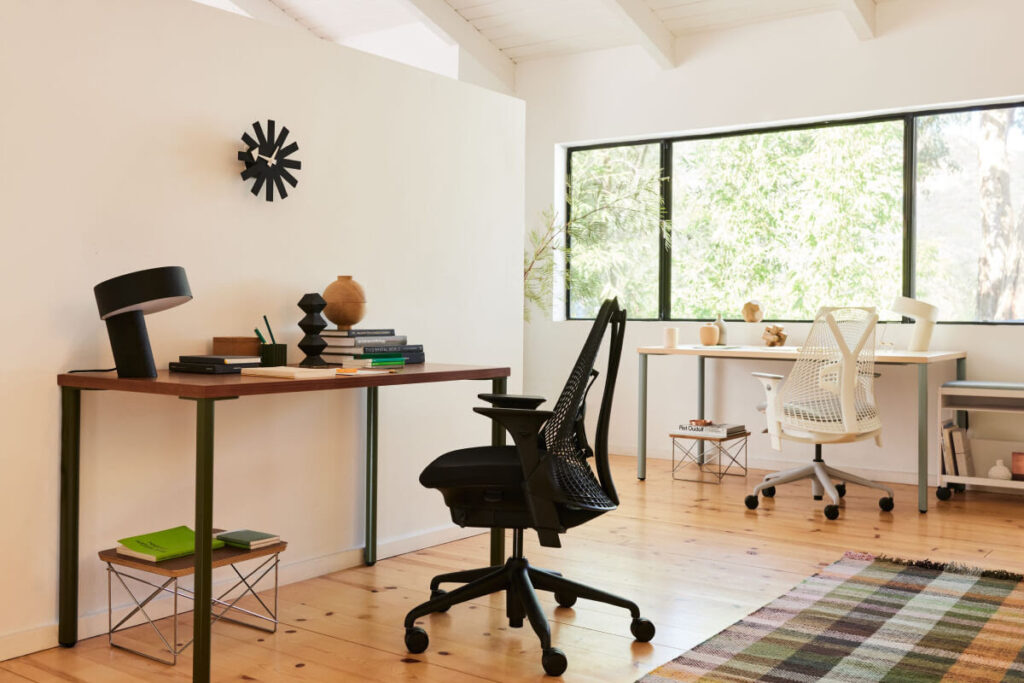 Imagem de ambiente residencial com duas mesas de trabalho, uma com a cadeira Sayl na cor preta, e outra na cor branca.