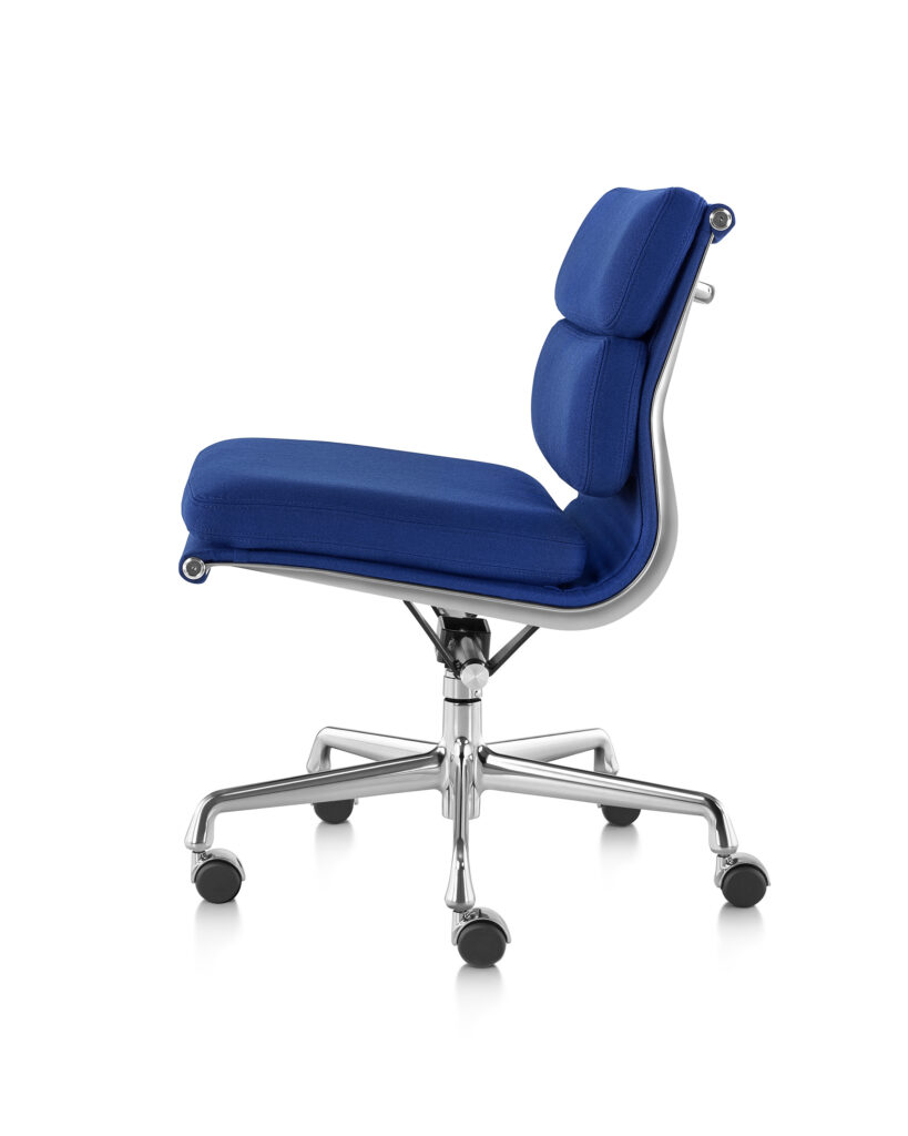 Vista lateral de uma cadeira Eames Soft Pad azul, com espaldar baixo, revestimento em tecido, base em alumínio polido, e sem braços.