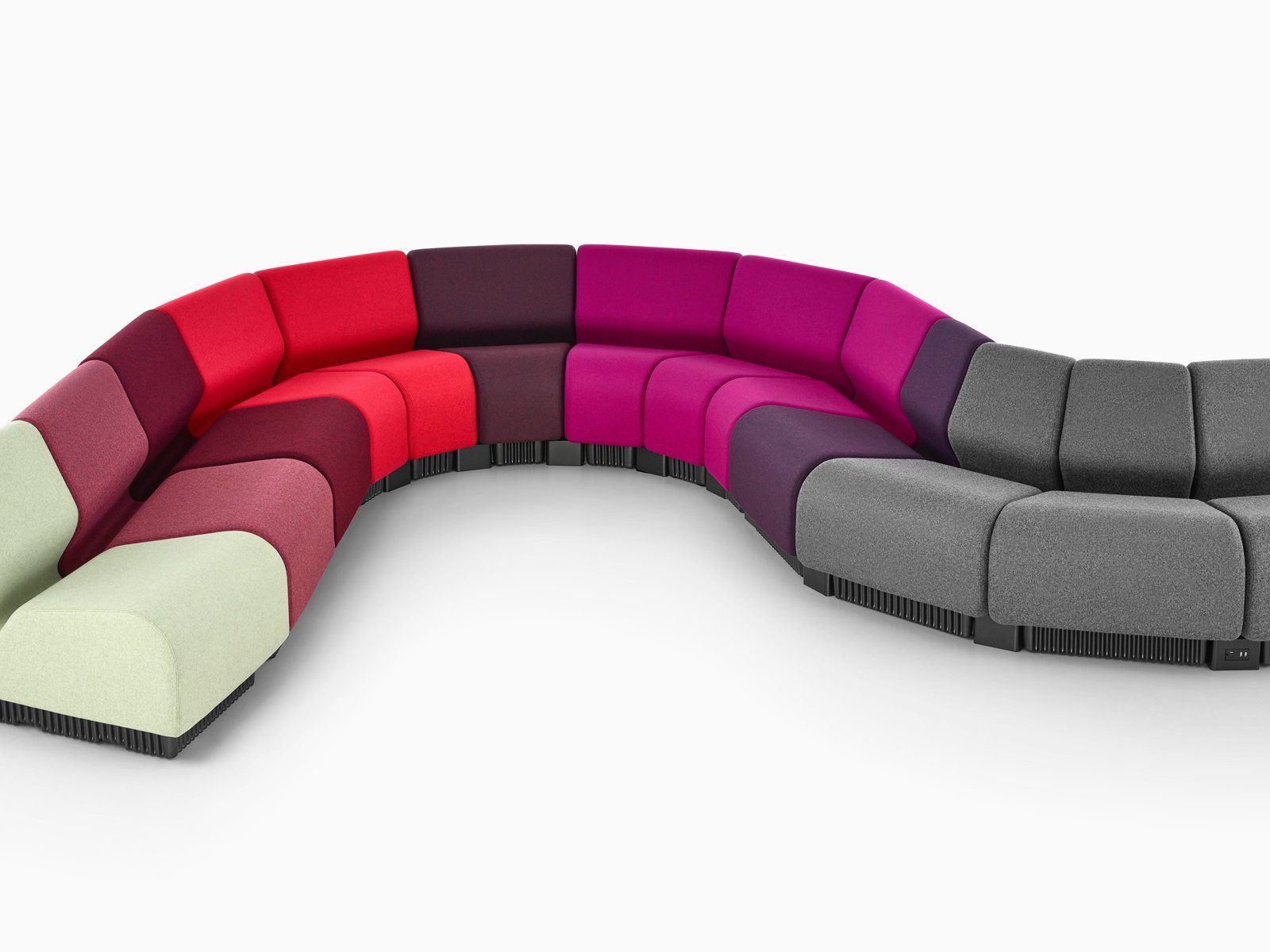 Diversos módulos do Assento modular Chadwick, em cores variadas, acoplados, e formando suas características curvas.